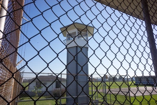 ANGOLA PRISON, LOUISIANA - OCTOBER 14, 2013: Looking thru a fence at a guard tower inside Angola Prison. The Louisiana State Penitentiary, also known as Angola, and nicknamed the "Alcatraz of the South" and "The Farm" is a maximum-security prison farm in Louisiana operated by the Louisiana Department of Public Safety & Corrections. It is named Angola after the former plantation that occupied this territory, which was named for the African country that was the origin of many enslaved Africans brought to Louisiana in slavery times. This is the largest maximum-security prison in the United States[with 6,300 prisoners and 1,800 staff, including corrections officers, janitors, maintenance, and wardens. It is located on an 18,000-acre (7,300 ha) property that was previously known as the Angola Plantations and bordered on three sides by the Mississippi River.
