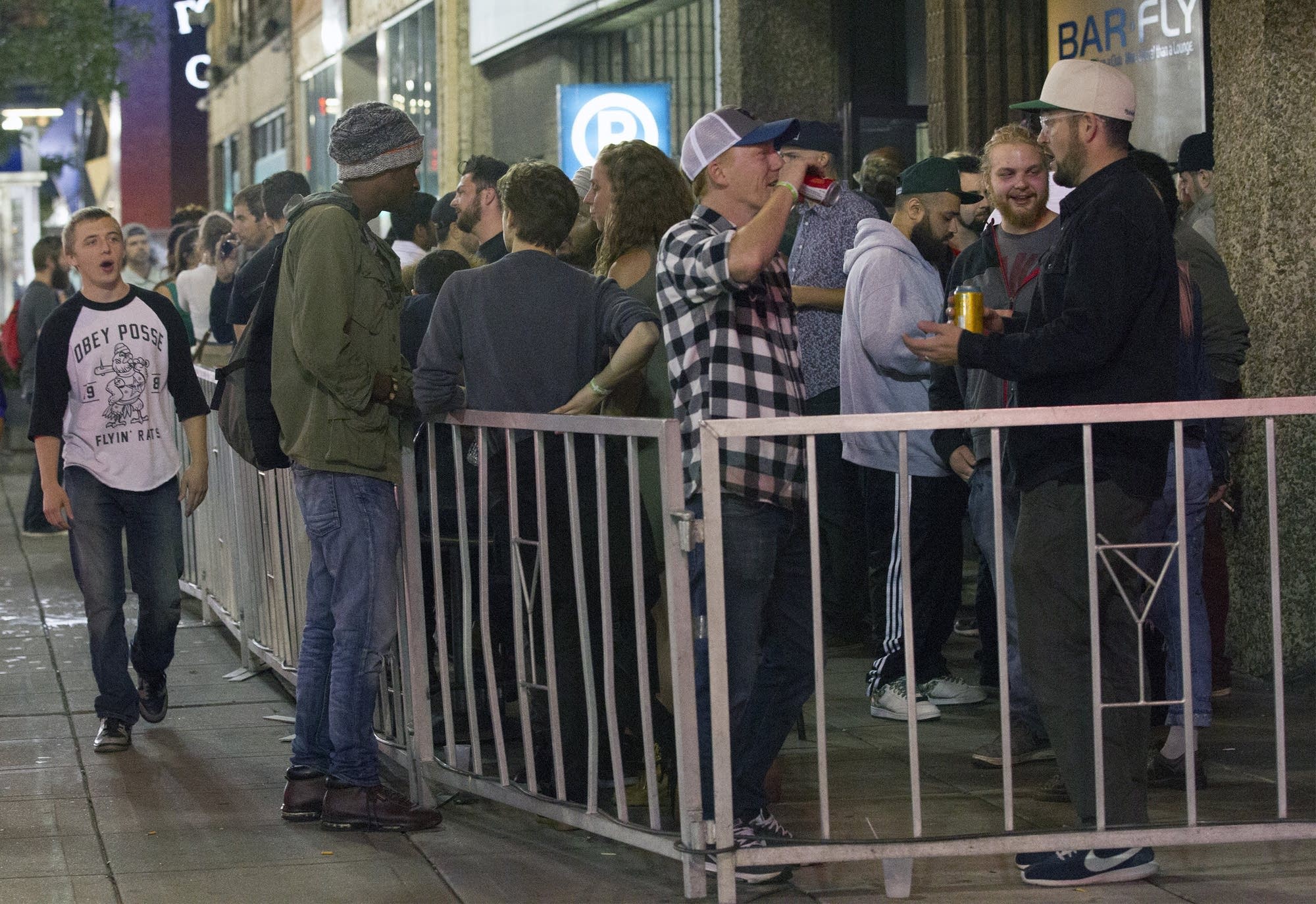 A crowd gathers outside the Bar Fly on Hennepin Avenue.