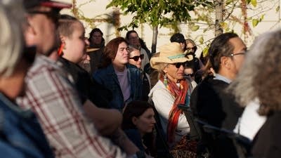 Community members listen to speakers