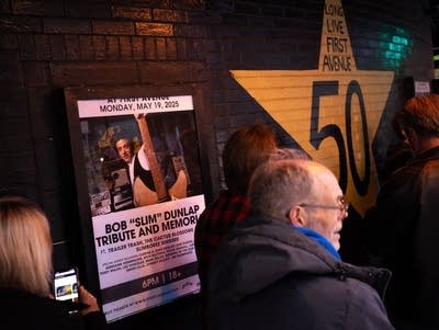 A poster hangs outside First Avenue. People walk by on their way in.