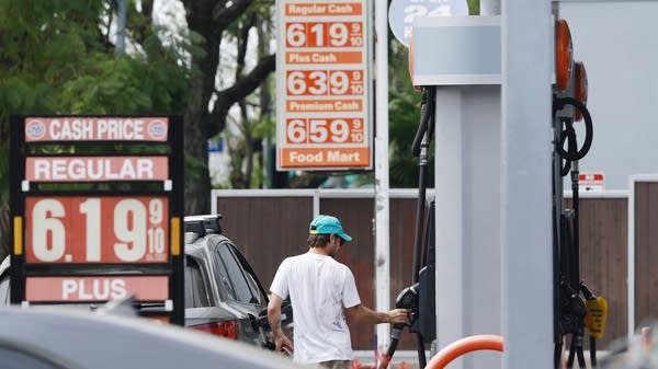 While bigger tax refunds may provide a bit of a cushion, some consumers will still have to cut back in the face of higher gas prices. Above, a person pumps gas at an LA gas station on Monday.