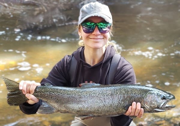 woman holding a rainbow trout