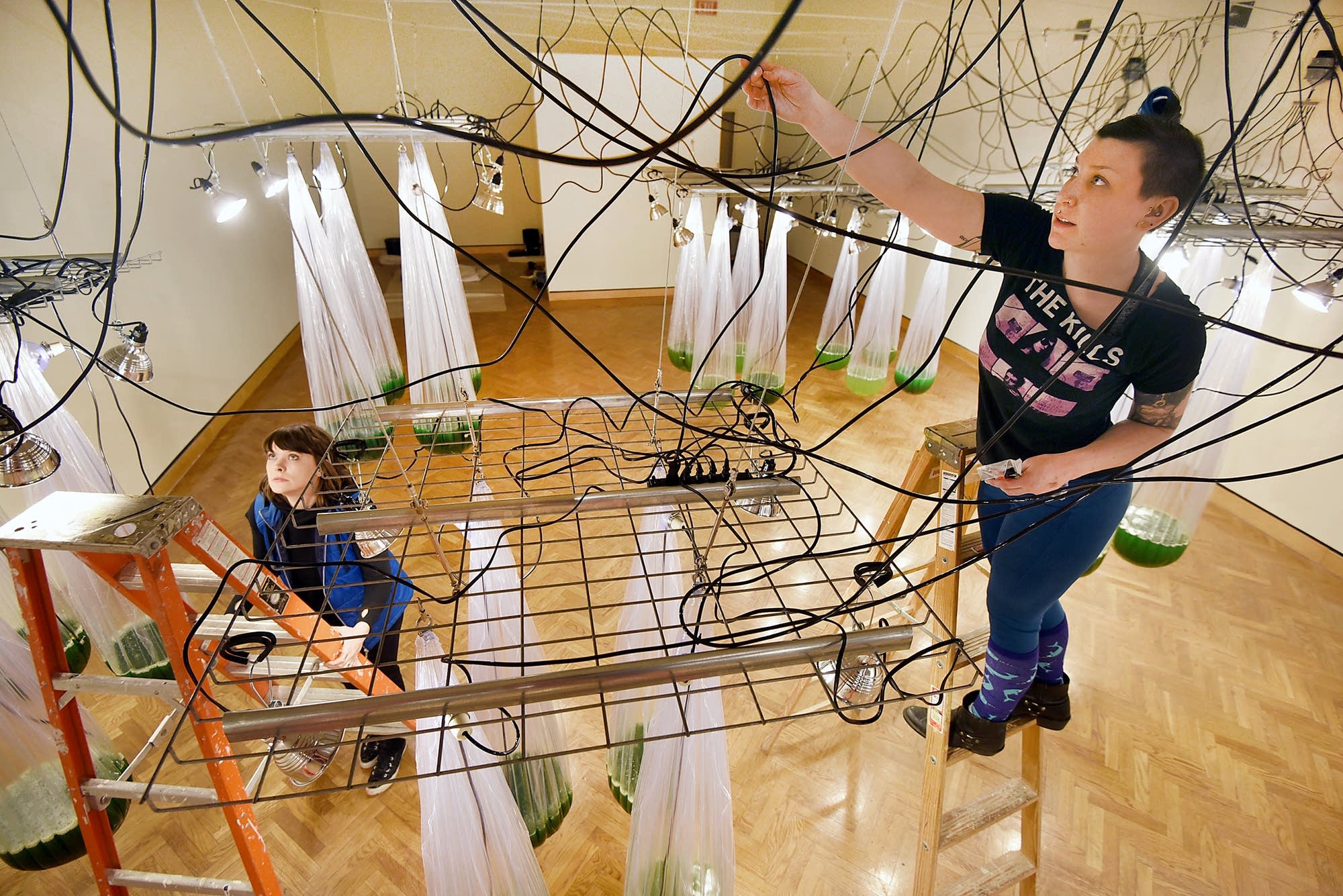 Brittany Reif-Wenner, left, and Sara Wichterman help hang the show.