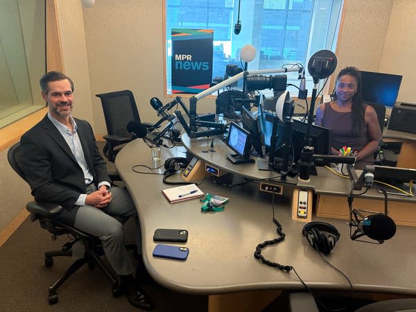 two people smiling in a broadcast studio