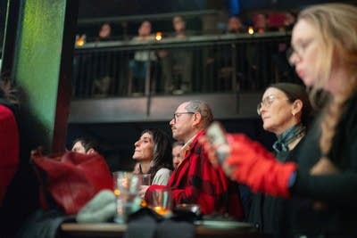 A room full of music fans watching a band perform onstage