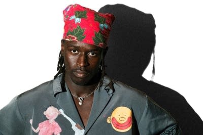 A man wearing a head scarf poses for a portrait