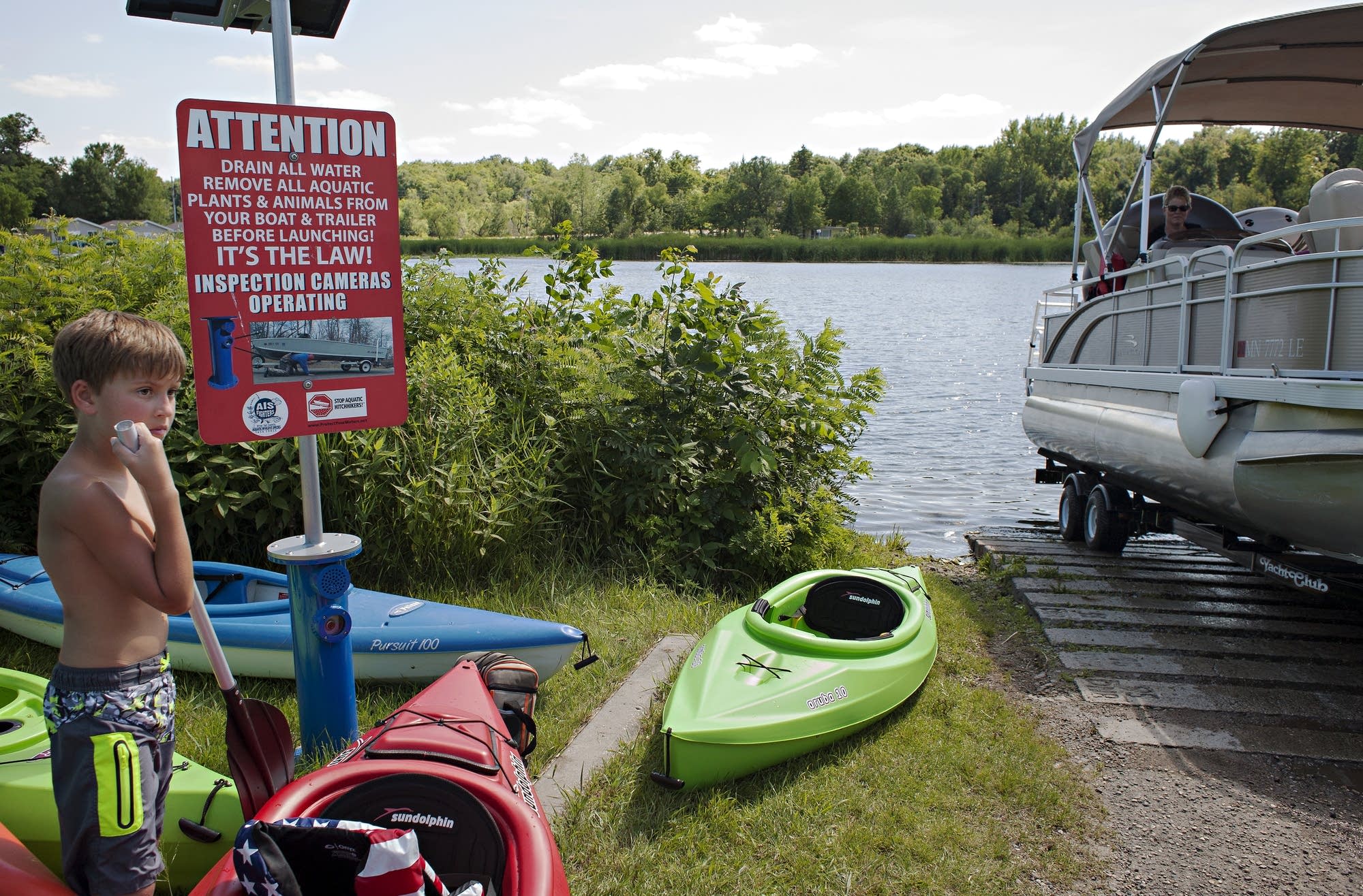 Dylan Johnson of Becker County waits while a pontoon exits Pelican Lake.