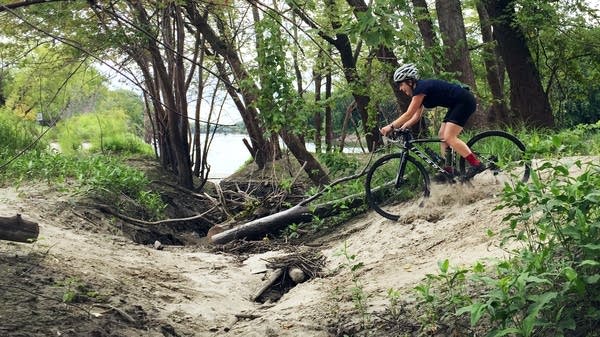 A woman rides a sandy trail