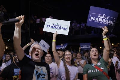 Political supporters hold signs for Peggy Flanagan.