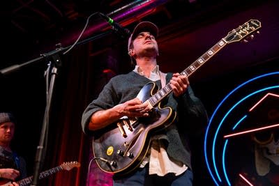 Man playing guitar with eyes closed on stage