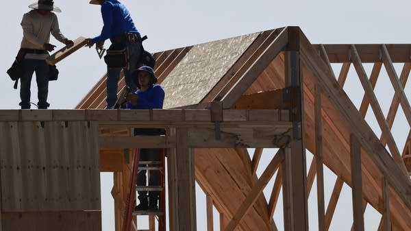 Construction workers build a home