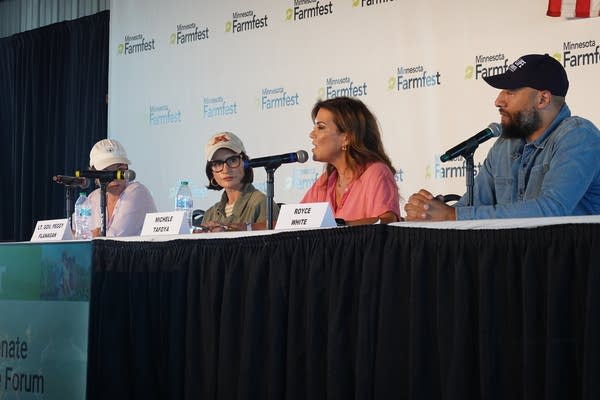 Four people sit at a table to talk during a debate.
