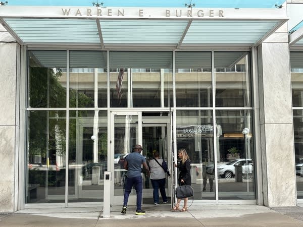 Three people enter a courthouse