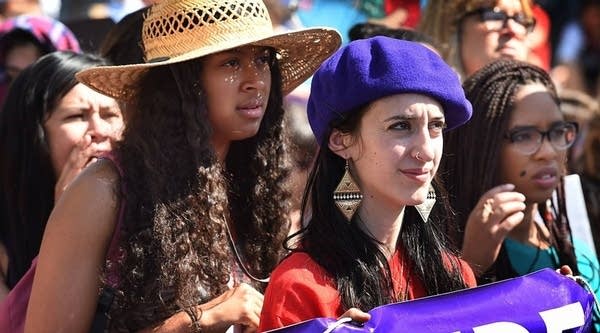 Women march behind a banner as they join other women's rights advocates at an International Women's Day march in downtown Los Angeles, California back in 2015.