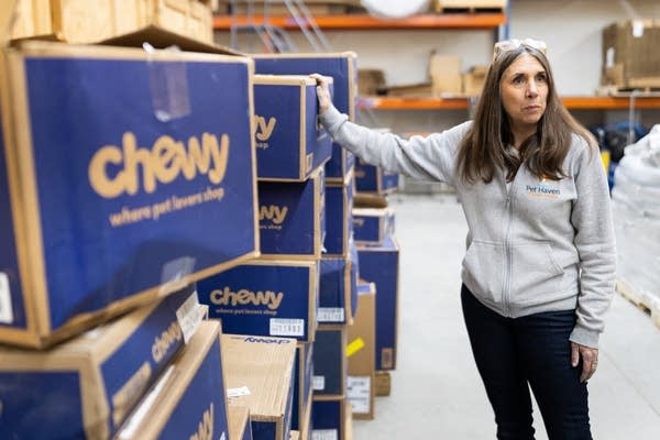 A woman stands in a warehouse