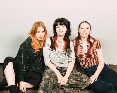 Three musicians sit together for a portrait