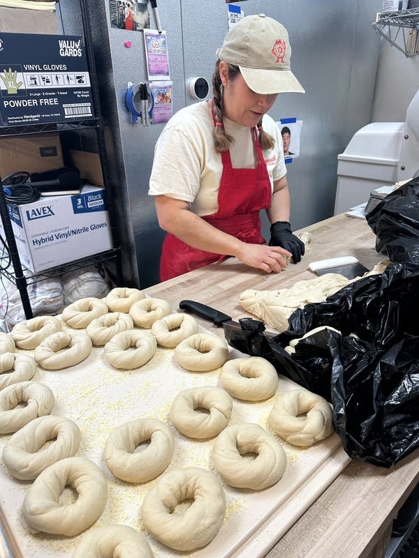 A woman prepares bagels.