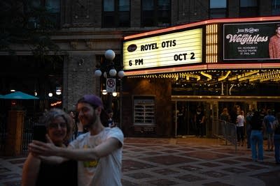 Music fans pose for a selfie outside a music venue
