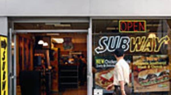 A man passes a Subway shop in New York City.