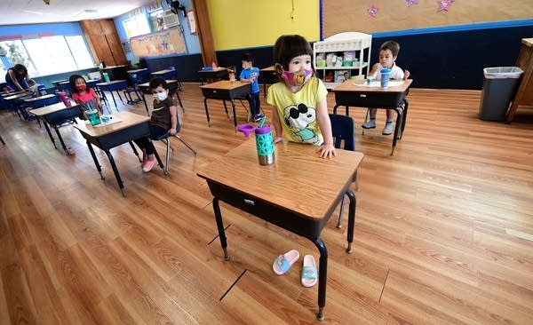 Children in a pre-school class wear masks and sit at desks spaced apart as per coronavirus guidelines during summer school sessions in Monterey Park, California on July 9, 2020. 
