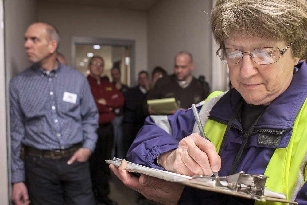 Mary Kempel takes notes during a news conference.