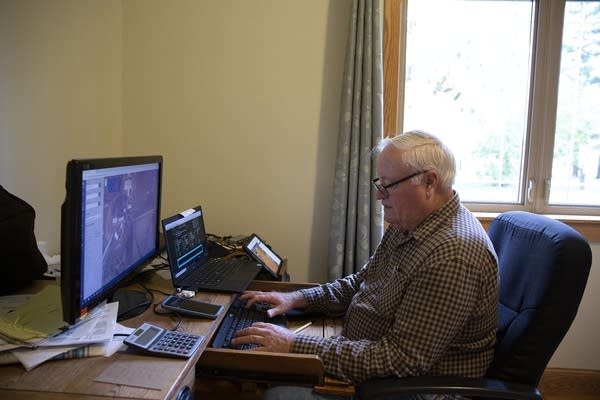 A man sits in front of a computer at a desk. 