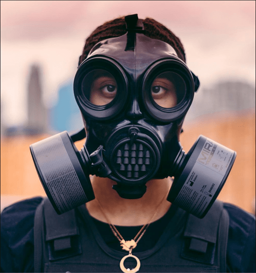 A man stands with a gas mask on.