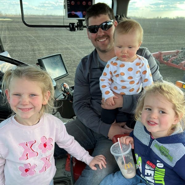 a man and three children on a tractor