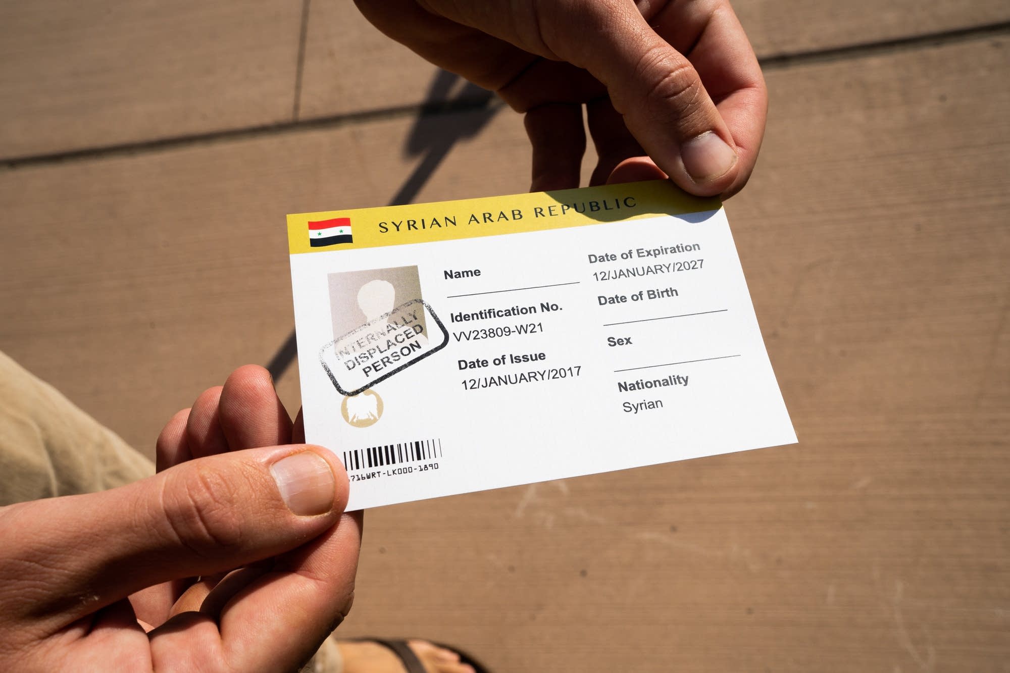 A Doctors Without Borders guide holds up a mock ID card.