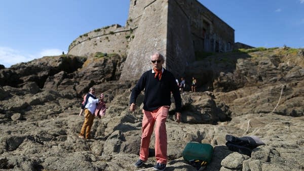 The owner of the Fort du Petit, available for rent on Airbnb, walks in front of the 17th century military fortress in northwestern France.