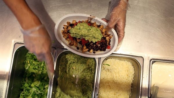 Chipotle restaurant workers fill orders for customers on the day that the company announced it will only use non-GMO ingredients in its food on April 27, 2015 in Miami, Florida.