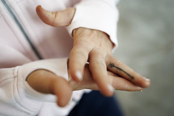 A person shows an arrow tattoo