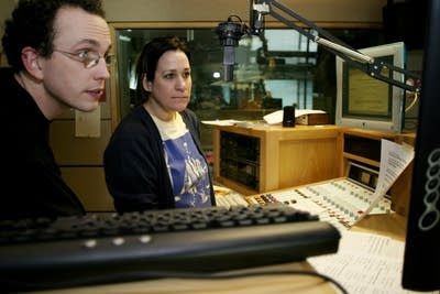 Two people converse in a broadcast studio