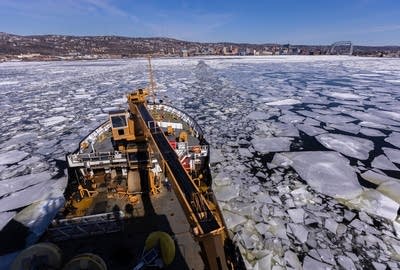 A large ship moves through an icy Lake Superior