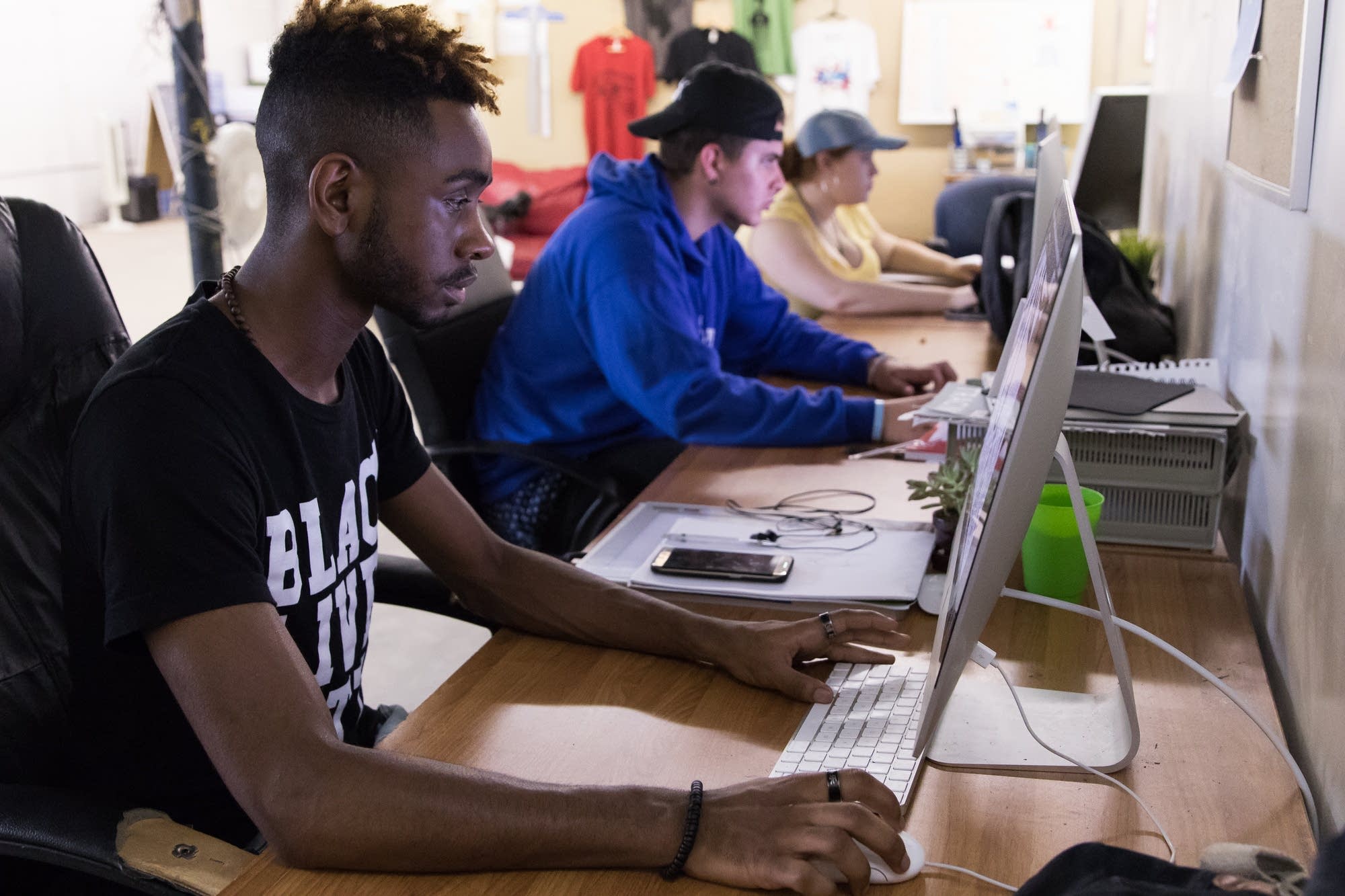 Junior art director D.J. Bryant, 17, works on a vinyl mural design.