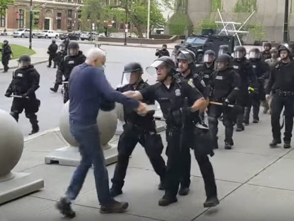 A Buffalo police officer shoves a man