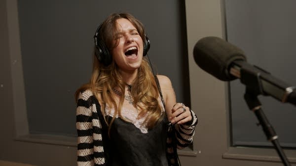 A musician singing in a recording studio