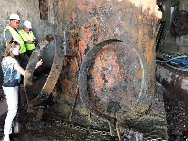 Workers and visitors examine the massive diving bell