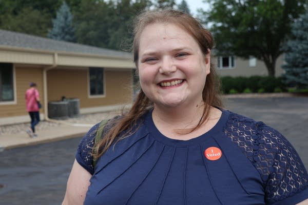 A woman poses for a photo outside a polling place.