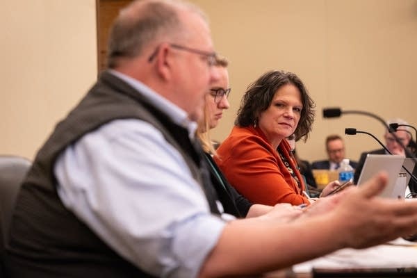 One person looks over while another talks.