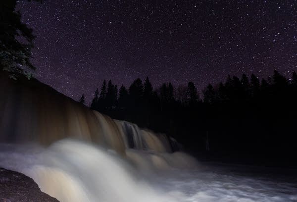 The Gooseberry Falls State Park middle falls flow under a clear night sky.