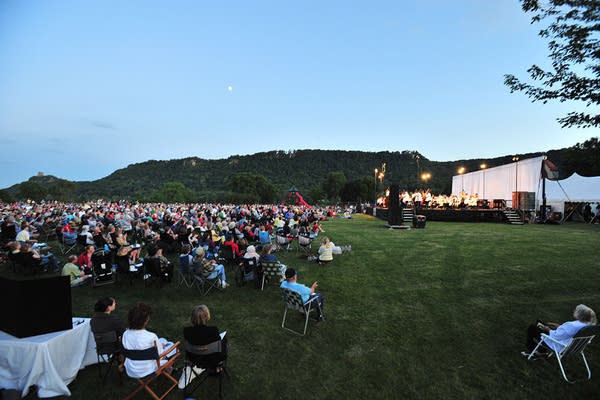 People sit on a lawn for a concert
