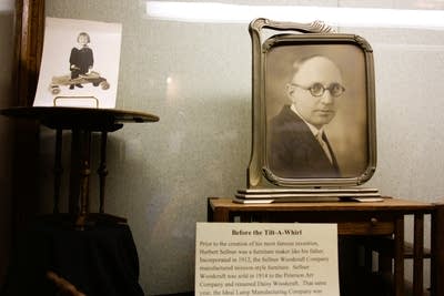 A black and white photo of a man with glasses is shown in a historical display.