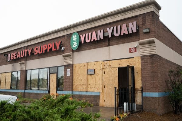 A restaurant with plywood on the front.