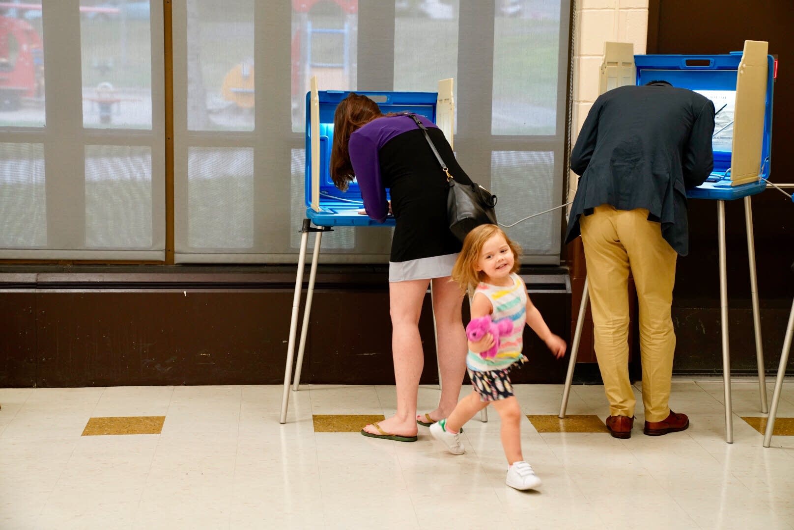 Sam, right, and Jen Rosenbaum vote with their daughter Ava.