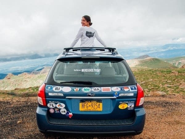 Mary Latham and the Blue Subaru she's driving across the country