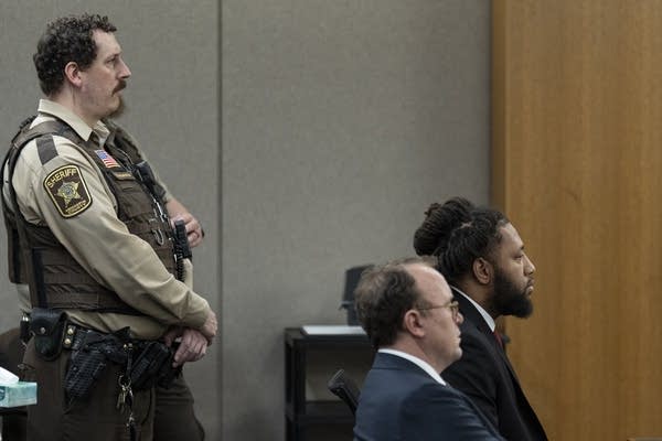 A man sits in a courtroom
