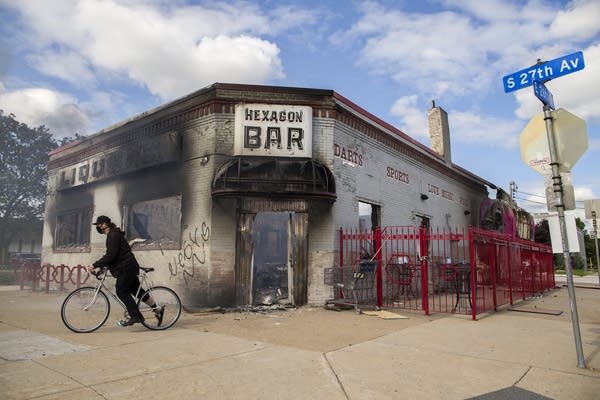 A person on a bike in a burned building. 