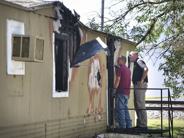 Investigators examine the scene of a fire at a mobile home in Paynesville.