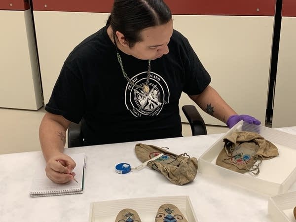 person at table with artifacts 
